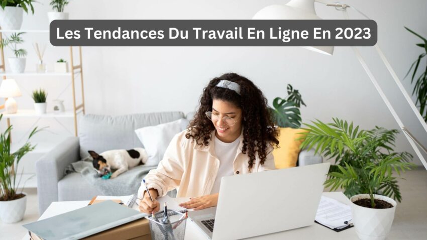 Une femme souriante et concentrée sur son travail en ligne sur son ordinateur portable.